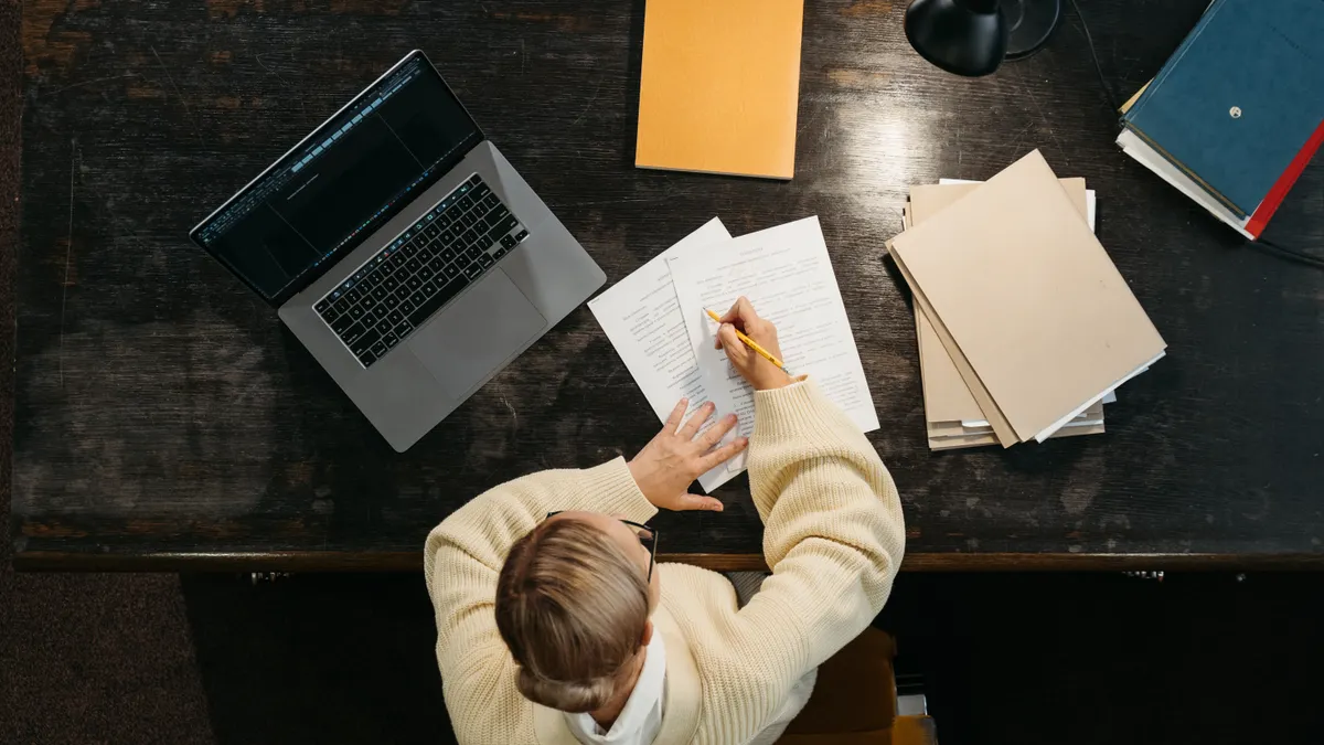 top-down view of writing, laptop, and scattered papers