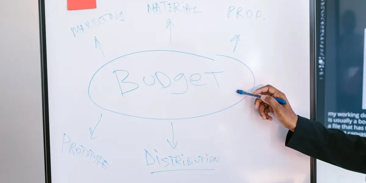 whiteboard with budget planning notes and arrows