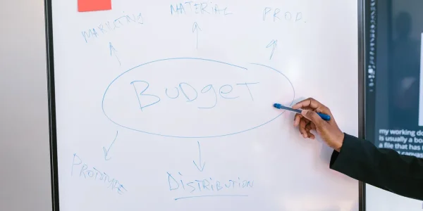 whiteboard with budget planning notes and arrows